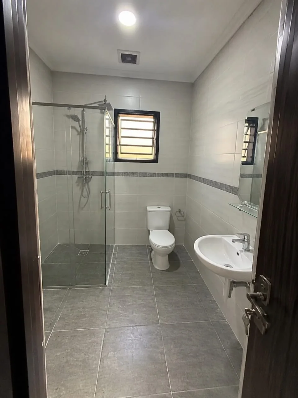 Salle d’eau équipée avec douche vitrée, sanitaire et lavabo